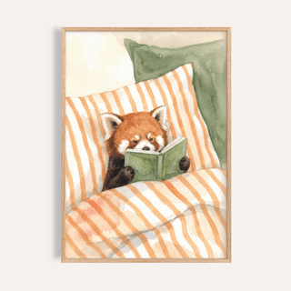 Framed Red Panda Reading Art Print of a red panda reading a green book with orange striped bedding