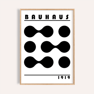 Framed minimalist geometric print with black abstract shapes and text in a light wooden frame