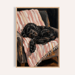Framed Cockapoo Poster of a black cockapoo dog lying on a pink and white striped throw