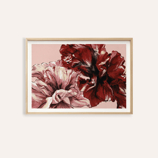 Framed print of red and pink abstract floral shapes with light wooden frame