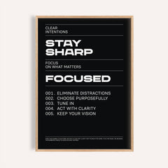 Stay Focused Poster with bold white text Stay Sharp on a black background in a wooden frame