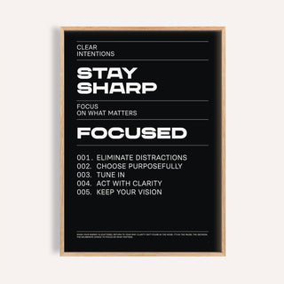 Stay Focused Poster with bold white text Stay Sharp on a black background in a wooden frame