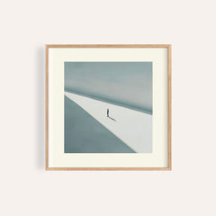Framed art print of a solitary person in shadow with minimalist light and grey tones