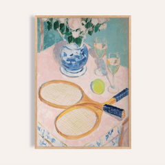 Framed print of tennis rackets with a ball and wine glasses on a pink tablecloth