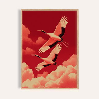 Framed Flying Cranes wall art of two red crowned cranes flying above orange clouds on dark red background