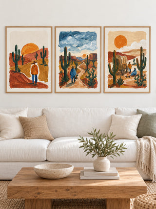 Desert Wall Art hung at eye level above a white linen sofa: Desert Sunset Print, Desert Walk and Desert Wagon shown framed side by side (frames not included)