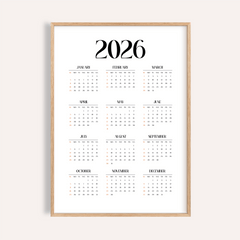 Minimalist wall calendar with black and orange text and numbers in a wood frame
