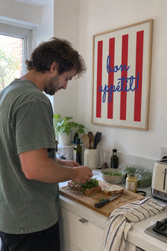 Man making a sandwich in his kitchen under the Bon Appetit Stripes print