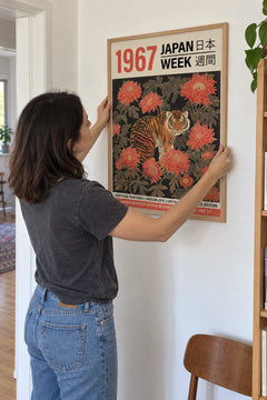 Woman hanging the Tiger's Grace print on her wall