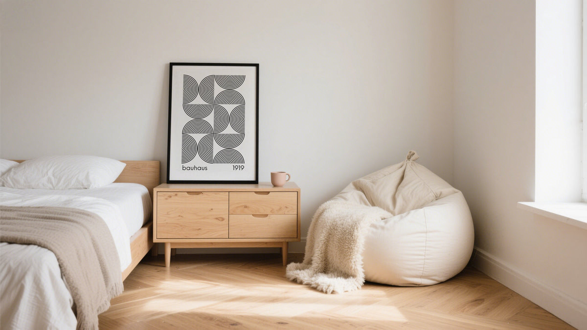 Framed minimalist poster on a sideboard in a modern neutral-toned bedroom