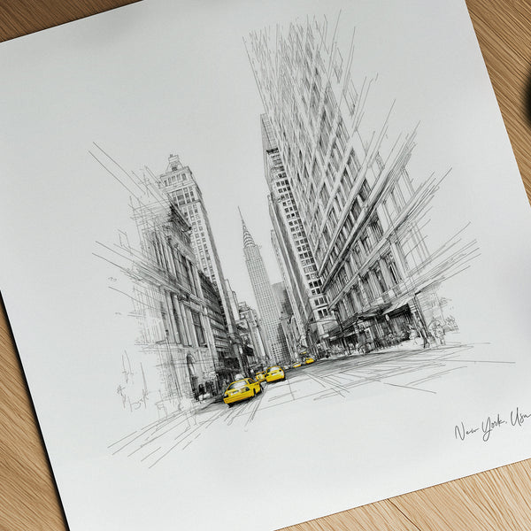 Black and white cityscape drawing with yellow taxis on a wooden surface