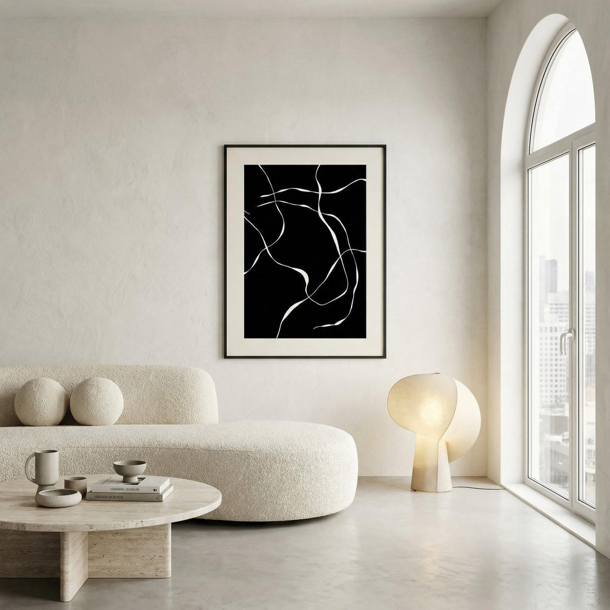 Modern living room with a black and white abstract art print on a white wall.