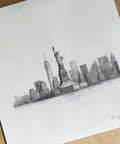 Black and white illustration of the Statue of Liberty and New York City skyline on a white sheet of paper.