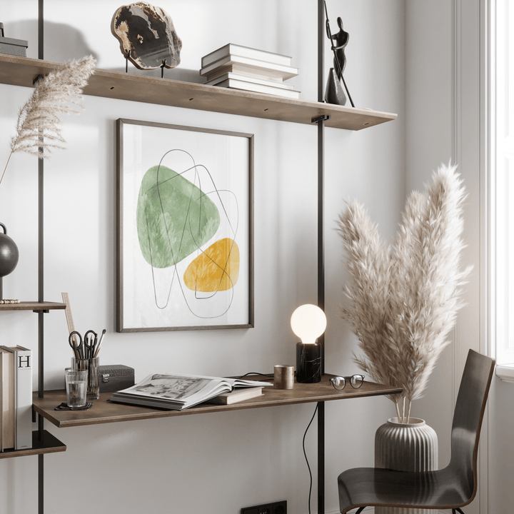 Abstract Watercolor Art hanging above a wooden desk with books and lamp in a bright room