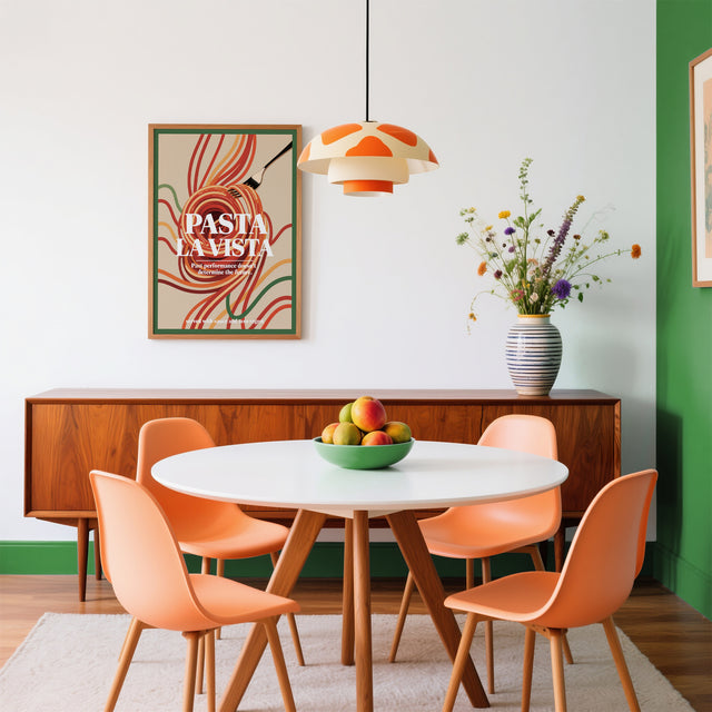 Dining room with round table, orange chairs, and a 'Pasta La Vista' poster on the wall.