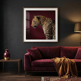 Framed artwork of a leopard on a dark wall above a purple sofa.