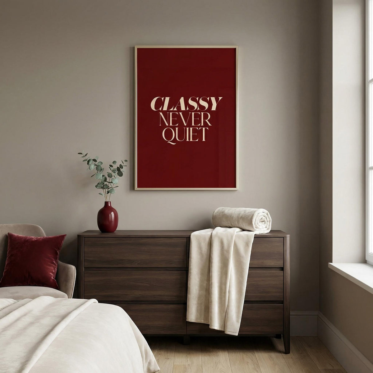 Modern bedroom with a dresser, bed, and framed classy tyography poster on the wall.