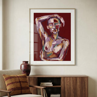 Framed abstract artwork of a nude figure on a wall above a wooden cabinet.