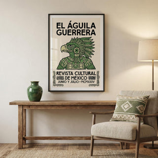 Framed artwork with 'El Águila Guerrera' on a wall above a wooden table with a vase and chair.