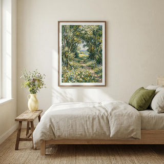 Bedroom with a painting of a forest scene on the wall, a vase with flowers on a side table, and a bed with white bedding.