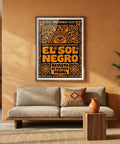 Living room with a 'El Sol Negro' poster on an orange wall, a beige sofa, and decorative elements.