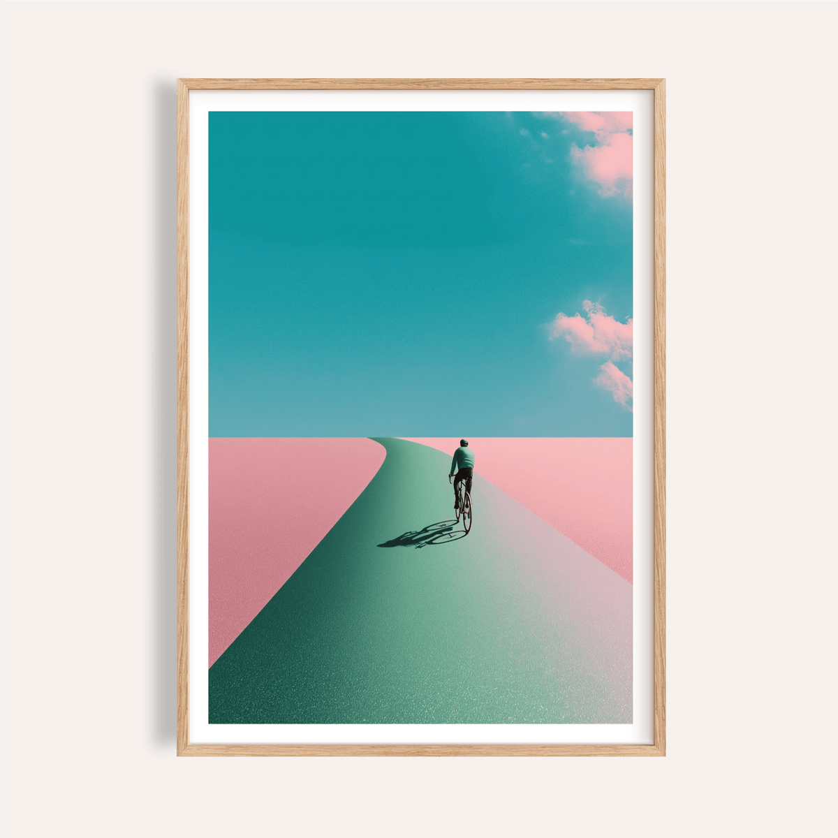 Framed mockup of Surreal Cycling Art Print poster with lone cyclist on a curved road under clouds