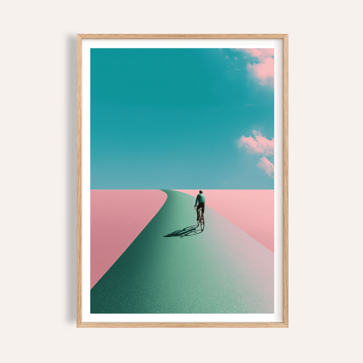 Framed mockup of Surreal Cycling Art Print poster with lone cyclist on a curved road under clouds