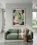 Modern living room with a green sofa, abstract art on the wall, and a small table with decor items.