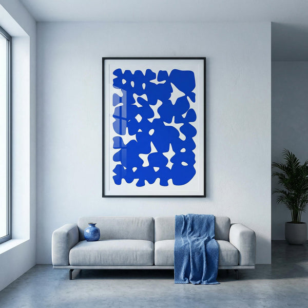 Modern living room with a gray sofa, blue abstract art, and a plant.