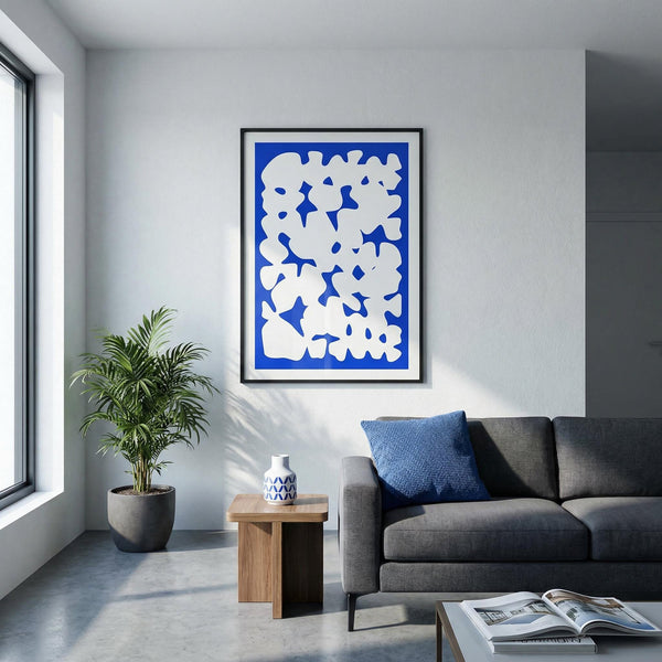 Modern living room with a gray sofa, plant, and abstract art on the wall.