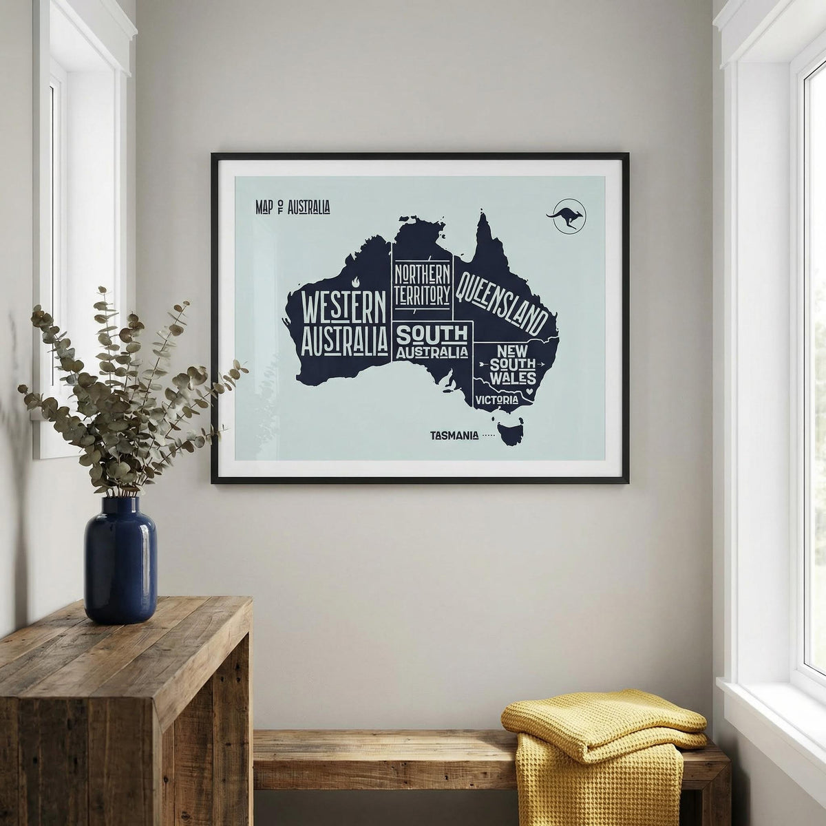 Framed map of Australia on a wall with a wooden console table and bench below.