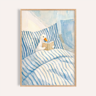 Above the bed, Duck Reading Art Print poster showing a duck reading a book on striped bedding