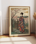 Vintage wall art print showing a kimono figure in a garden with flowering branches and distant hills