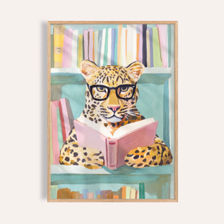 Centered leopard in glasses reading a pink book wall art print with bookshelf background