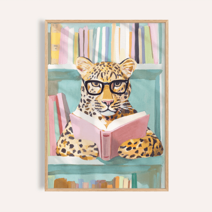 Centered leopard in glasses reading a pink book wall art print with bookshelf background