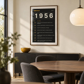 1956 Arrivals Board Print, framed on the wall of a modern dining room with a cream wall