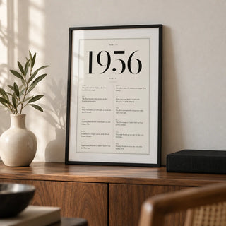 1956 Birthday Print, a small A4 framed print leaning on a walnut sideboard in a living room