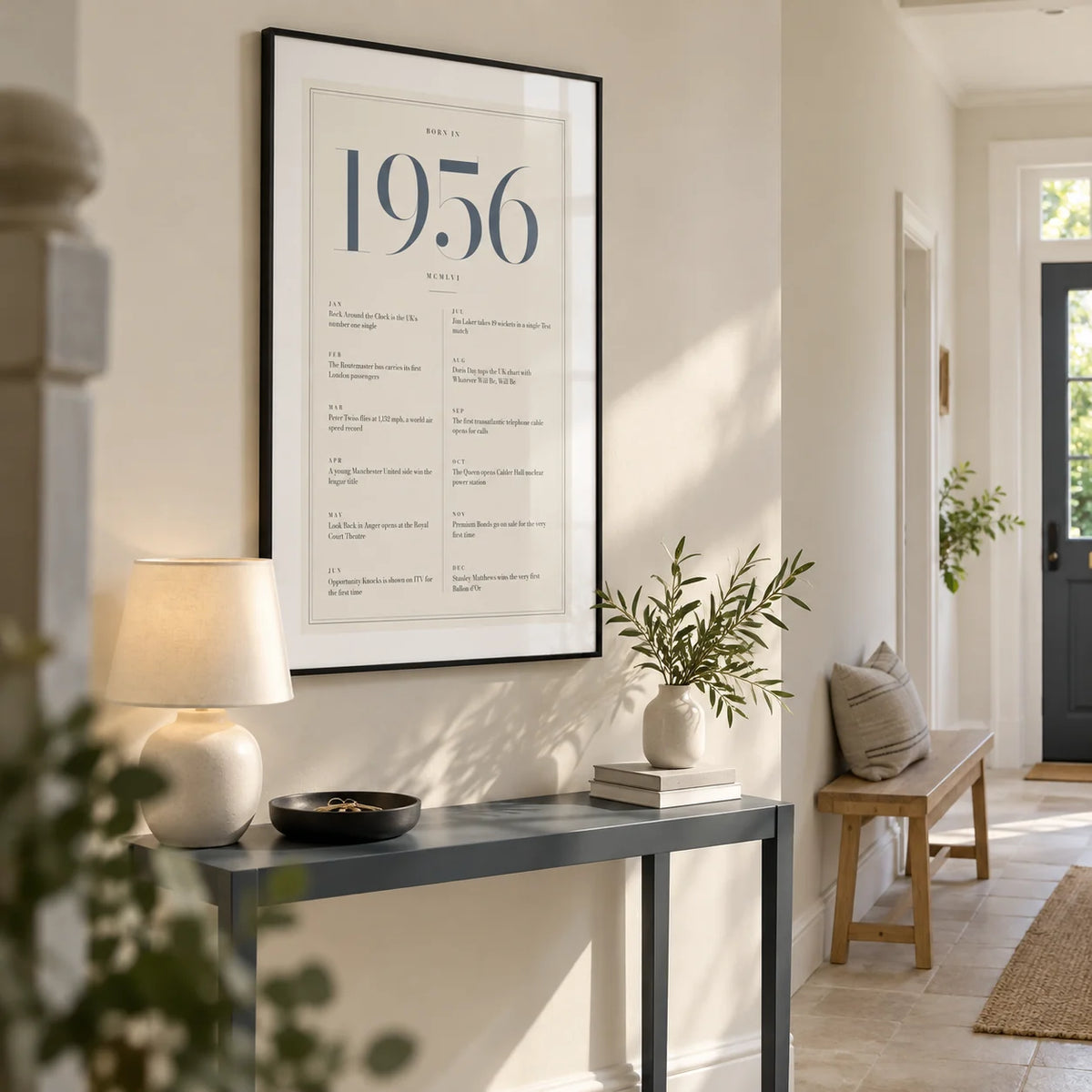 1956 Blue Birthday Print, framed on the wall of a welcoming hallway in a renovated UK semi-detached home with an ivory wall and pale stone floor