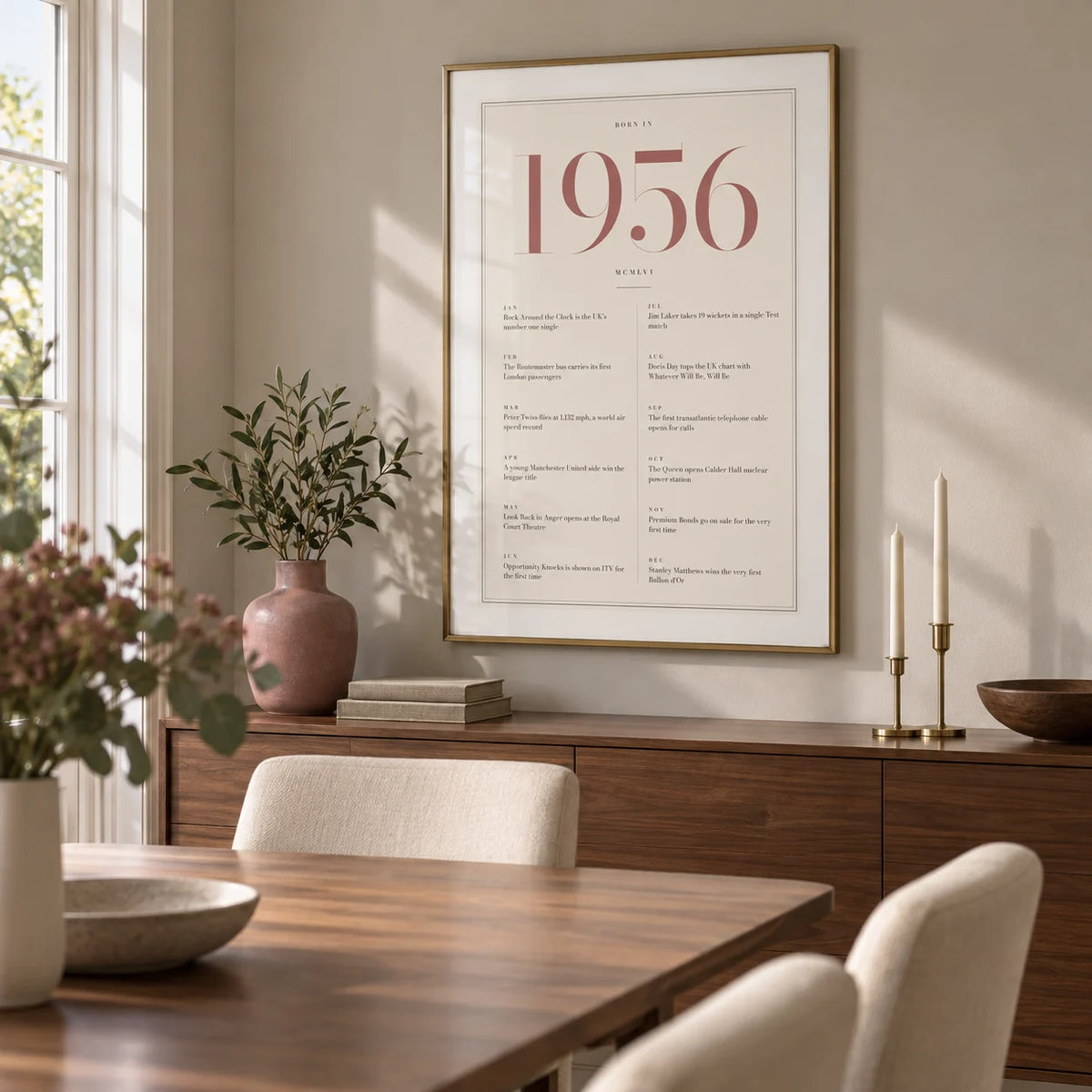 1956 Pink Birthday Print, framed on the wall of a contemporary dining room in a British family home with a pale warm grey wall and a walnut dining table
