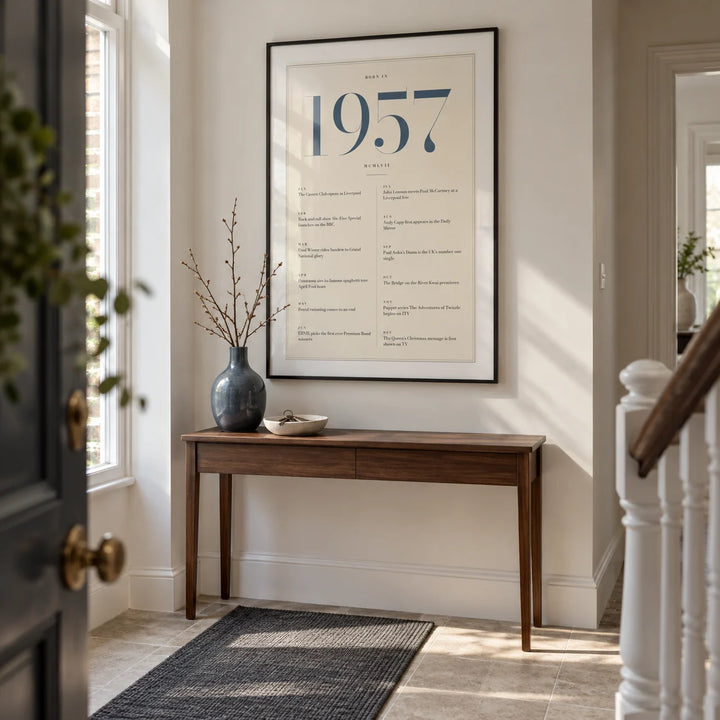 1957 Blue Birthday Print, framed on the wall of a smart entrance hallway in a renovated British terraced house with an off-white wall and pale stone floor
