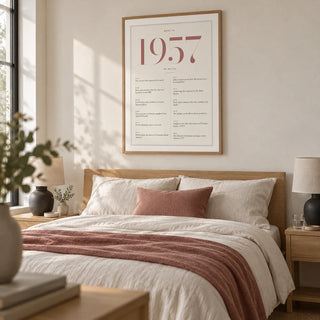 1957 Pink Birthday Print, framed on the wall of a serene grown-up bedroom with a warm white wall and pale oak furniture