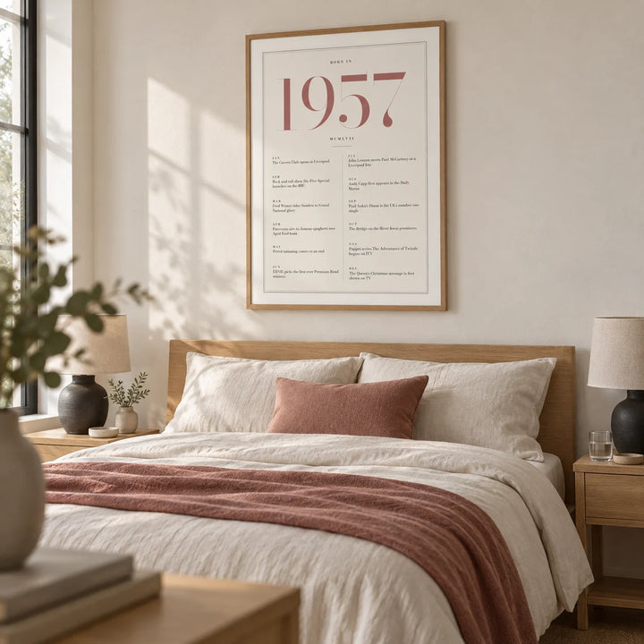 1957 Pink Birthday Print, framed on the wall of a serene grown-up bedroom with a warm white wall and pale oak furniture