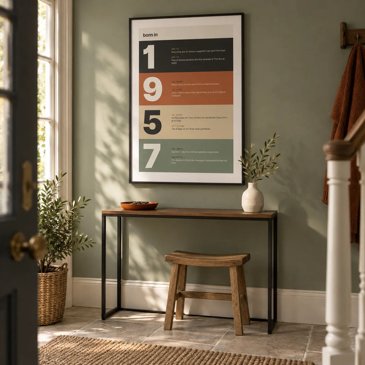 1957 Typography Print, framed on the wall of a compact entrance hall in a British townhouse with a muted sage green wall and pale stone flooring