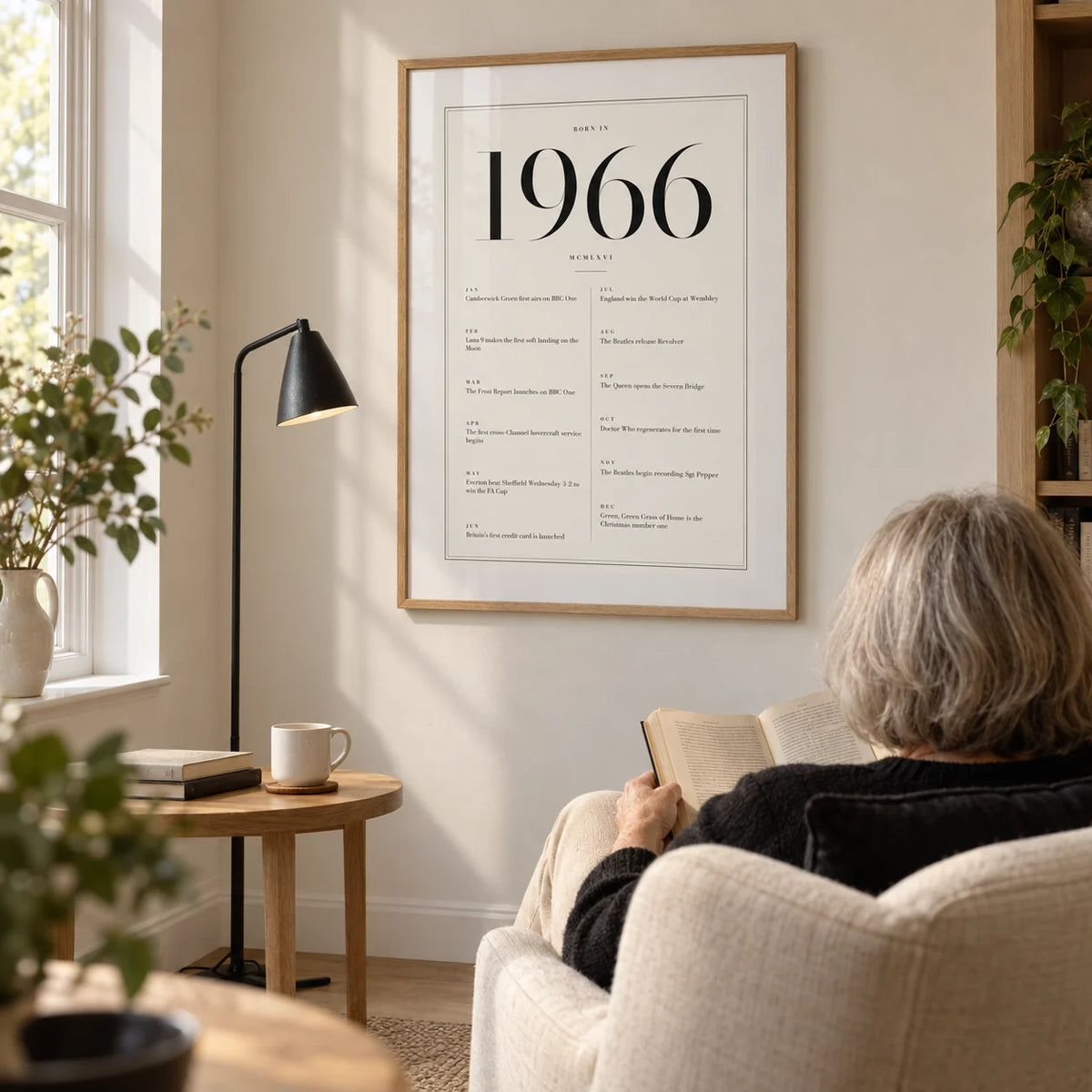 1966 Birthday Print, framed on the wall of a bright reading corner in a mature couple's UK home with a warm white wall and pale oak floor in a living room