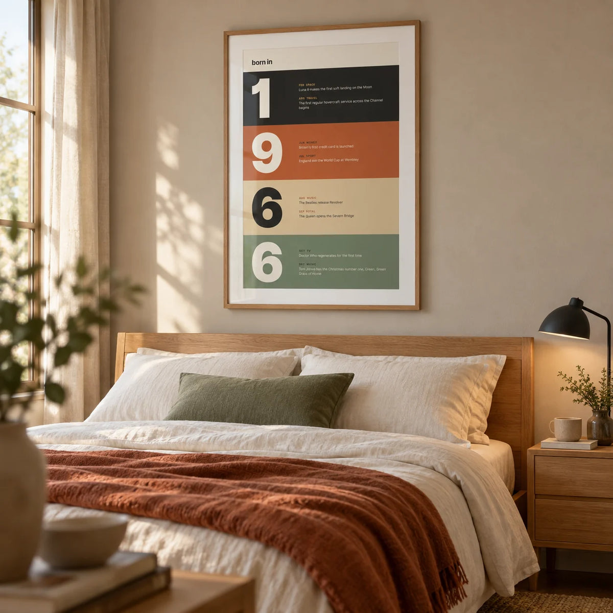 1966 Typography Print, framed on the wall of a modern main bedroom for a couple in their late fifties or sixties with a soft sand wall and clean oak furniture