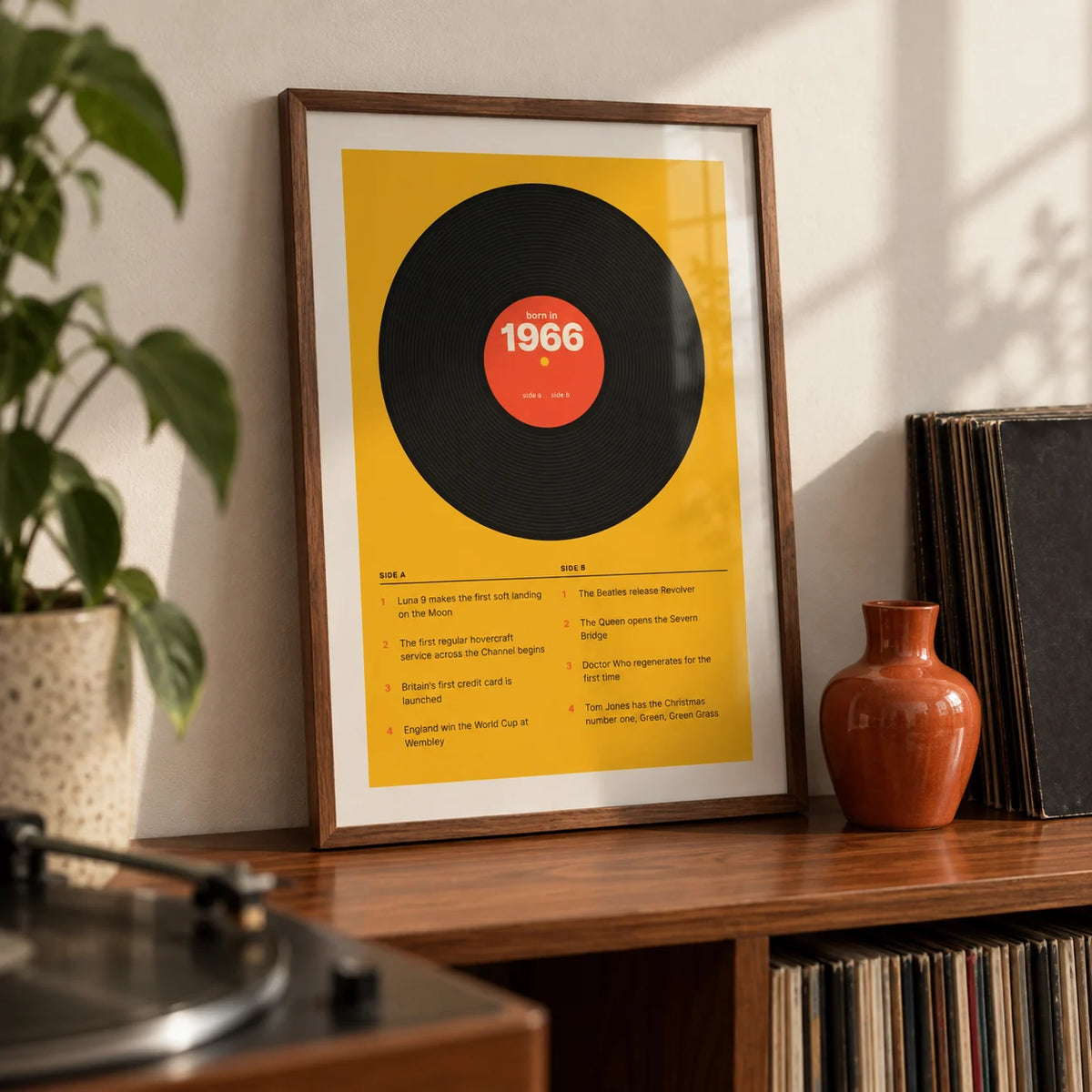 1966 Vinyl Record Print, a small A4 framed print leaning on a walnut record shelf in a living room