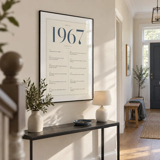 1967 Blue Birthday Print, framed on the wall of a bright entrance hallway in a renovated UK semi-detached house with a warm white wall and oak floorboards