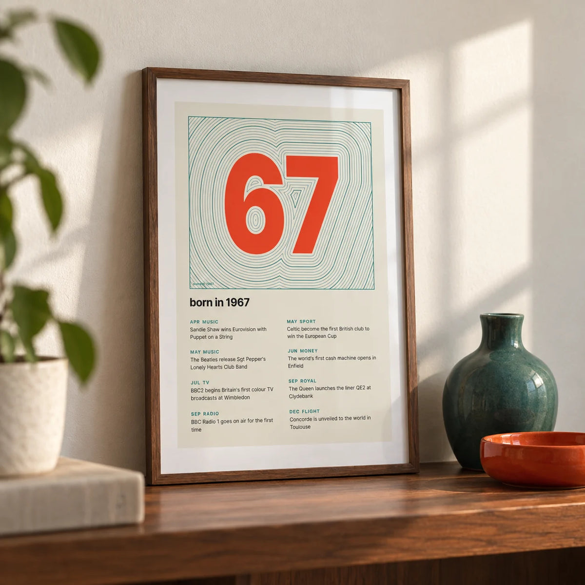 1967 Contour Map Print, a small A4 framed print leaning on a walnut shelf in a living room