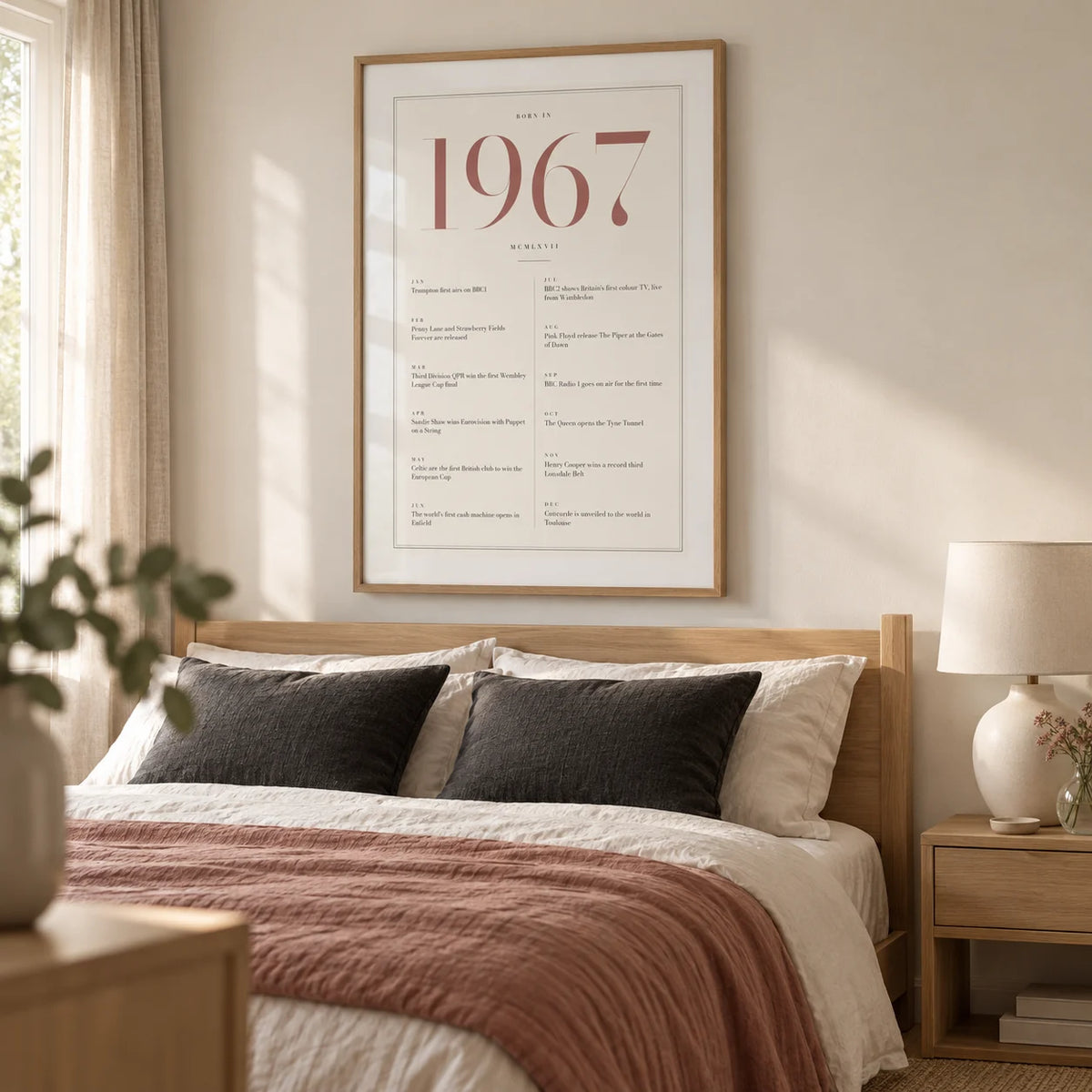 1967 Pink Birthday Print, framed on the wall of a tailored main bedroom in a UK home with a warm white wall and pale oak furniture