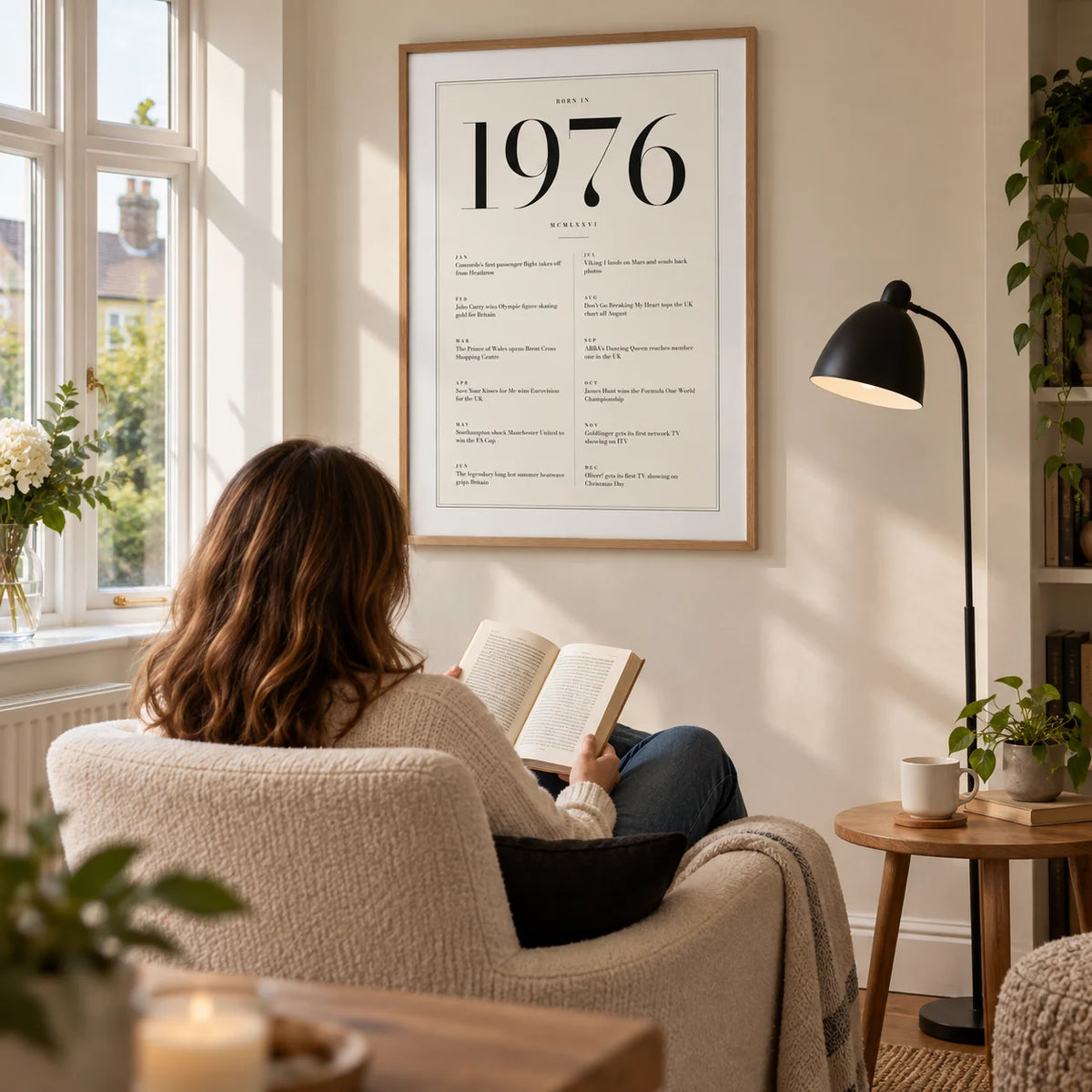 1976 Birthday Print, framed on the wall of a comfortable reading corner beside a bay window in a UK home with a warm white wall in a living room